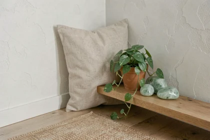 Pierre verte claire et pierres de jade disposées sur une étagère en chêne dans un salon zen minimaliste avec décoration naturelle